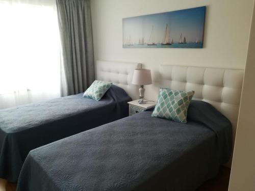圣克鲁斯Tamariz Flat的酒店客房设有两张床和窗户。