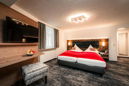米特尔贝格Hotel Tradizio的卧室配有红色和白色的床和椅子