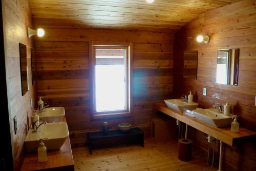 妙高björk （森の宿 ビヨルク）的一间带三个盥洗盆和窗户的浴室