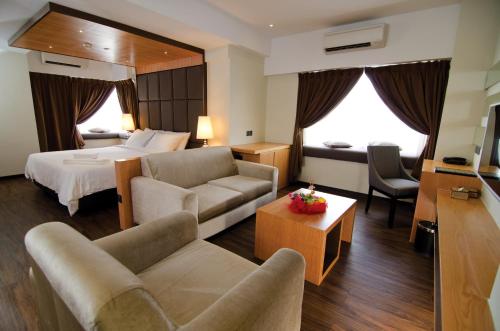 哥打京那巴鲁查亚旅馆的酒店客房设有床和客厅。