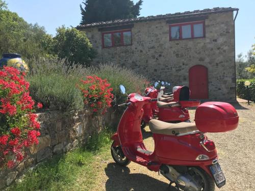 Badia A PassignanoIl Fiorino di Badia的停在房子前面的一辆红色摩托车