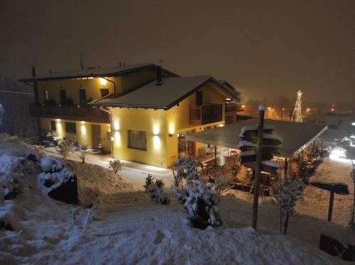 RanicaAgriturismo La Soglia Del Parco的夜晚雪中的房子