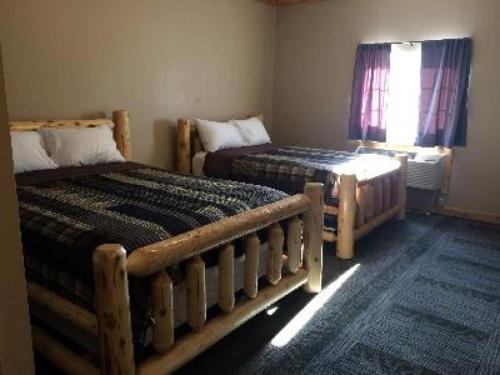 LewistownBig Horse Inn and Suites的一间卧室设有两张床和窗户。