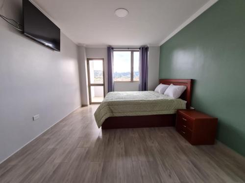 昆卡Hostal Morlaquita的一间卧室设有一张床和一个大窗户
