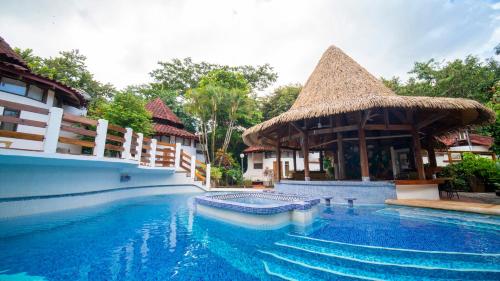 塔马林多Hotel Luna Llena的一座带小屋的度假村的游泳池