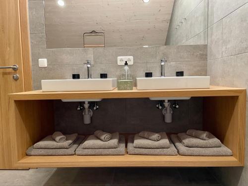 梅劳Wasserfall Apartments Mellau的浴室设有两个水槽和毛巾。