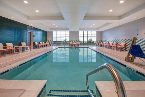 伊利Holiday Inn - Erie, an IHG Hotel的大楼内带桌椅的大型游泳池
