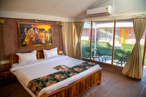 焦特布尔Kurja Resort Balsamand的一间卧室设有一张大床和一个大窗户