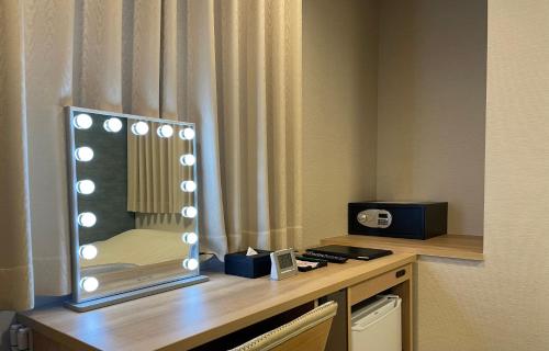 明石市Remington Hotel的在酒店房间桌子上的镜子