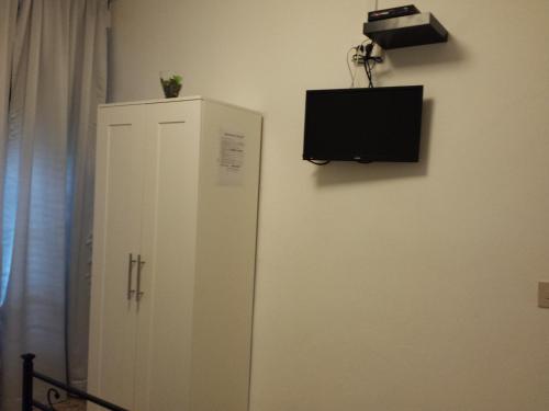比萨Casa Giulia的墙上有电视的白色橱柜
