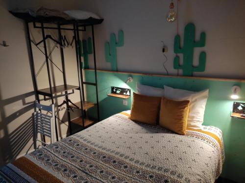 阿列日河畔的塔拉斯孔Hôtel Confort 09 ou HC-09的一间卧室,配有一张带仙人掌床头板的床