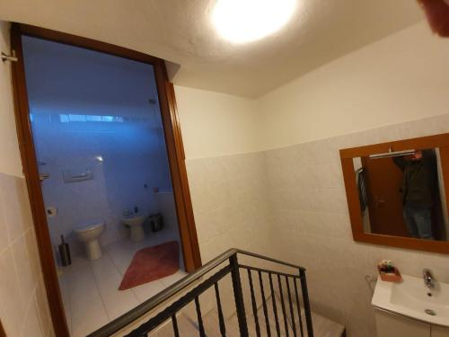 洛韦雷Casa Mirella的一间带卫生间、水槽和镜子的浴室