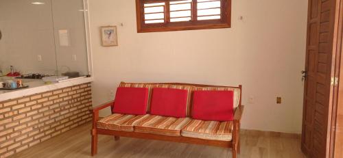 弗雷谢拉斯Casa Tropicana的厨房里配有两张红色枕头的长凳