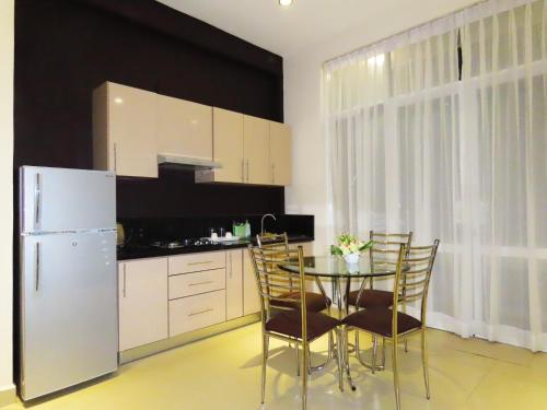 科伦坡VIVAS Residencies Luxury Apartments的厨房配有桌椅和冰箱。