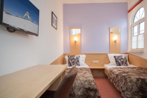 温特贝格Hotel Kiepenkerl的客房设有两张床、一张桌子和一台电视机。