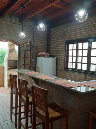 圣若昂-达巴拉Casa/chalé Furnas - Capitólio MG的厨房设有配有椅子和灯具的酒吧