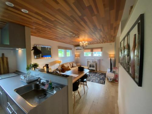 岐阜Vacanza Resort的厨房和带木制天花板的客厅