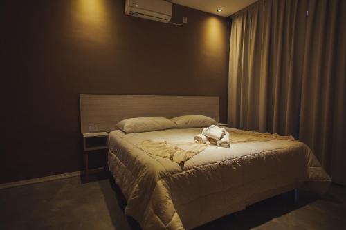 伊瓜苏港Paraiso Natural Apart Hotel Iguazu的卧室里设有一张床,上面有一只动物