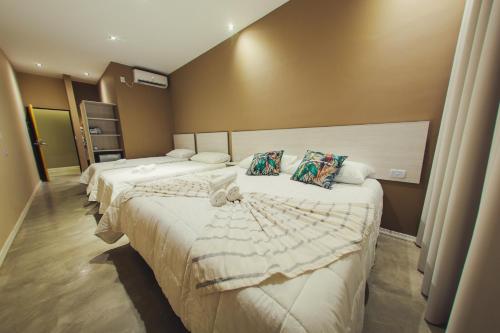 伊瓜苏港Paraiso Natural Apart Hotel Iguazu的酒店客房,配有两张带白色床单的床