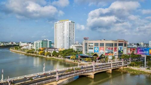 Ấp Ðông An (1)Căn hộ Khách sạn cao cấp Marina Plaza Long Xuyên的一座建有建筑物的城市里河流上的桥梁