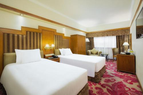 澳门澳门新丽华酒店的酒店客房配有两张床和一张书桌
