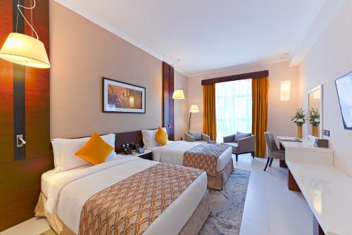 迪拜TIME Asma Hotel的酒店客房带两张床和一个客厅