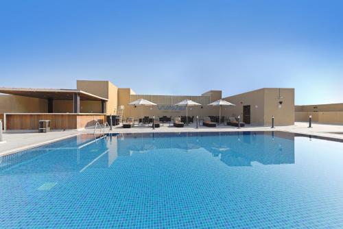 迪拜TIME Asma Hotel的大楼前的大型游泳池