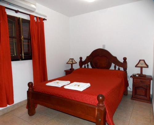 ChicoanaPortal De Los Valles的一间卧室配有一张红色床罩的床