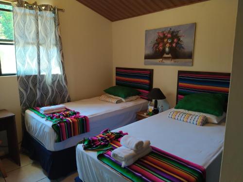 Antiguo CuscatlánHotel Antiguo的一间设有两张床铺和毛巾的房间