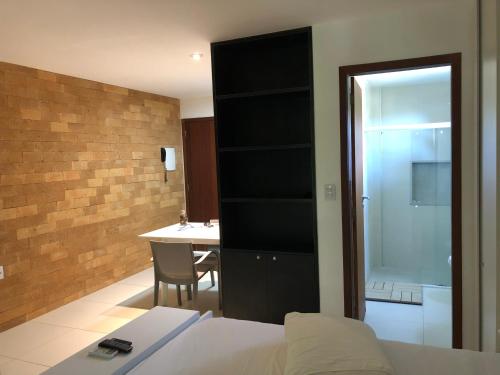 马塞约Villas do Pratagy - Pitanga B3的一间卧室配有一张床,浴室设有桌子