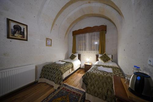 格雷梅阿克王宫酒店的客房设有两张床、一张桌子和一扇窗户。