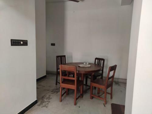 蓬蒂切里Villa Souhayl homestay的一张木桌和椅子