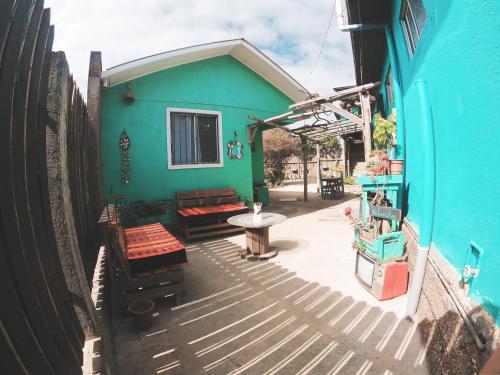 皮奇勒姆Los Rukos Cabanas (Bungalows)的蓝色的建筑,设有带桌子和长凳的庭院