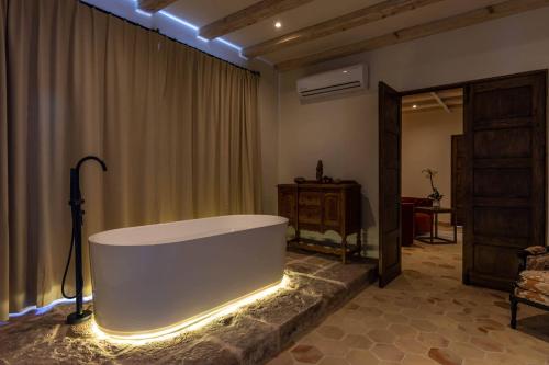 圣米格尔-德阿连德Casa 1810 Parque Hotel Boutique的大型浴室设有浴缸和灯光
