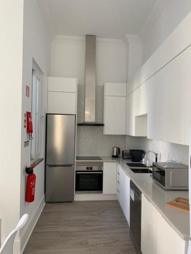 奥良Casa Cubista的厨房配有白色橱柜和不锈钢冰箱