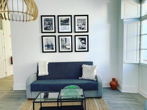 奥良Casa Cubista的客厅里一张蓝色的沙发,墙上挂着照片