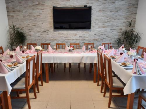 KraslicePension Krista的一张长桌子,配有椅子和粉红色的餐巾