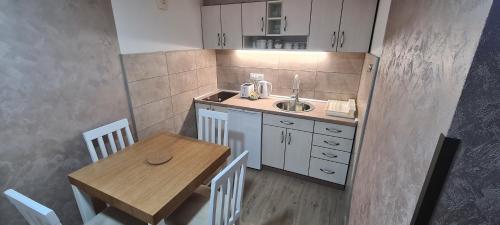 新瓦罗什Apartmani Božović的一个带桌子和水槽的小厨房