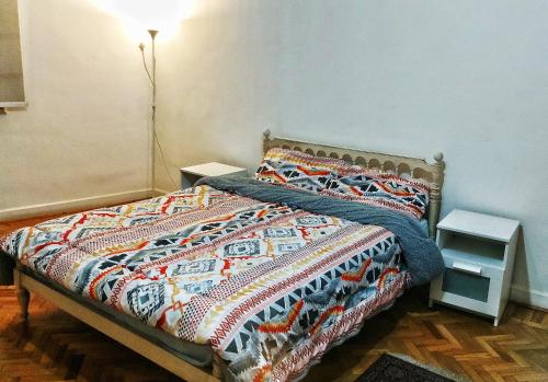 开罗Jessy Charming apartment in Heliopolis的卧室内一张带五颜六色棉被的床