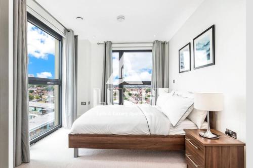 伦敦Modern, Stylish PENTHOUSE Apartment next to Wembley Stadium!的一间卧室设有一张床和一个大窗户