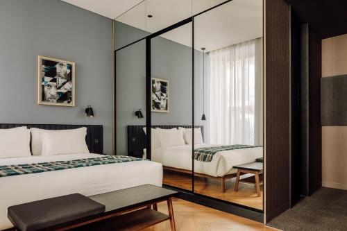 里斯本Hotel Hotel - Member of Design Hotels的一间卧室配有两张床和镜子