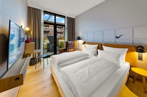 不莱梅Unique by ATLANTIC Hotels Bremen的酒店客房设有一张大床和一台电视机。