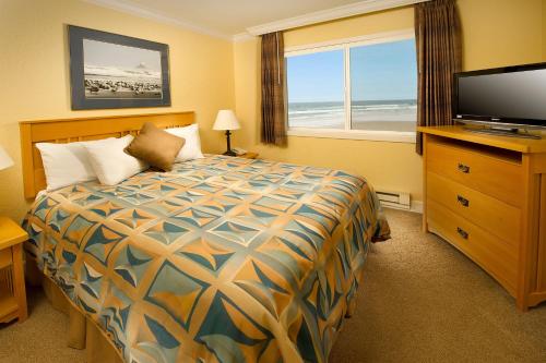 卡农海滩托尔瓦纳公寓式酒店的酒店客房,配有床和电视