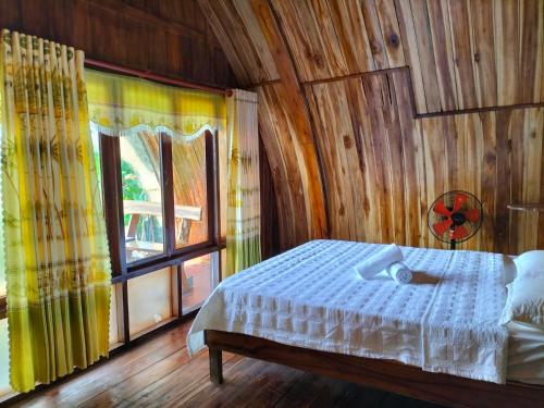 Quan TomRice straw Green lodge- resort的一间卧室设有一张床和一个大窗户