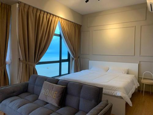 关丹Kuantan Seaview Studio@Imperium Residence TgLumpur的一间卧室配有一张床、一张沙发和一个窗口