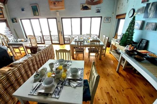 蚝湾牡蛎湾海滩酒店的用餐室配有桌椅和圣诞树