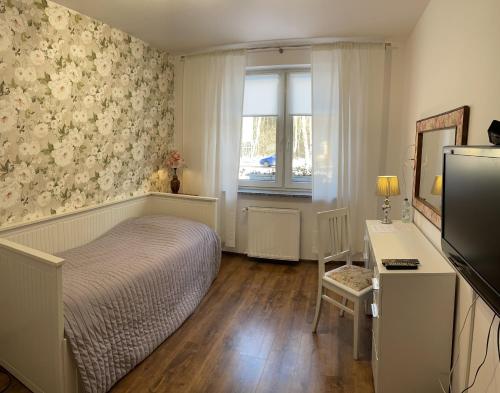 波兹南格森尼克波德布左扎米旅馆的一间卧室配有一张床、一张书桌和一个窗户。