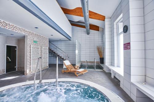 塔莱Hotel Stupka的设有带按摩浴缸的浴室和小型游泳池