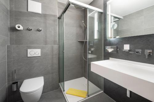 哈尔伯格摩斯Hotel Neuwirt的带淋浴、卫生间和盥洗盆的浴室