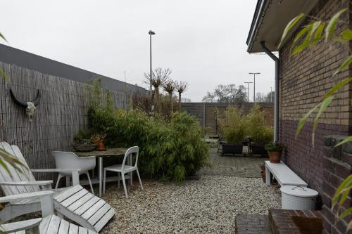 赞丹De oude slaght- luxe suite met buitensauna的一个带桌椅和砖墙的庭院